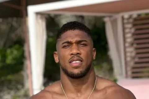 Anthony Joshua shows off shredded physique and looks ready for battle while sitting on beach ahead of Usyk rematch